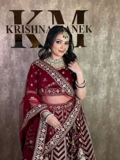 A three-quarter view of the maroon velvet rental lehenga, highlighting the intricate work on the dupatta and blouse.