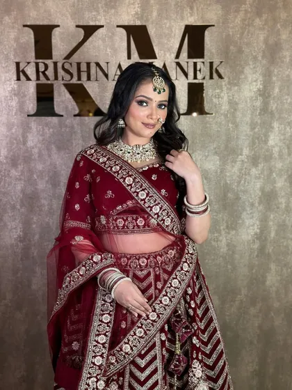 A three-quarter shot of the maroon velvet lehenga, showing the drape of the dupatta and the intricate work on the blouse.