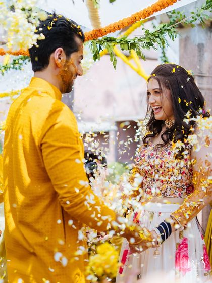 A candid moment of the couple sharing a laugh during their flower shower at the Fort Neemrana Haldi.