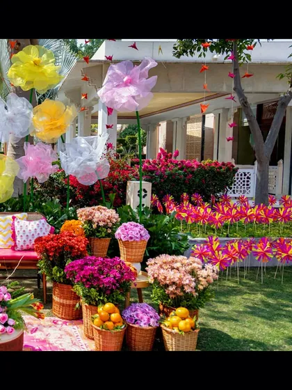 Another view of the Mehendi garden setup, with the colorful floral photo booth in the background and guest seating in the foreground.