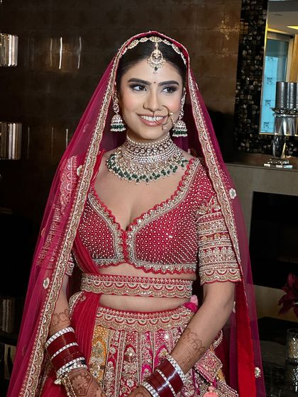 A smiling bride with her hair neatly tied back, ready for her big day.