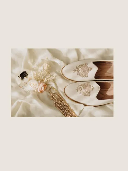 An artistic flat-lay of the groom's accessories, including his custom-monogrammed shoes. These details add a layer of personal style to the wedding story.