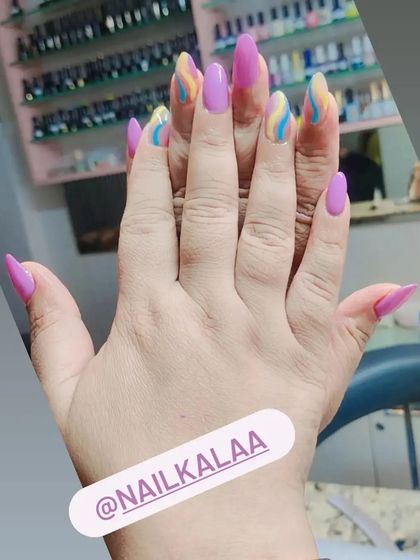 A playful design with solid pink nails and accent nails featuring colorful pastel swirls.