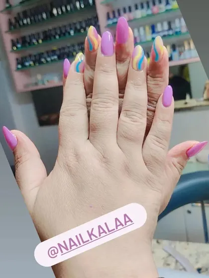 A playful design with solid pink nails and accent nails featuring colorful pastel swirls.