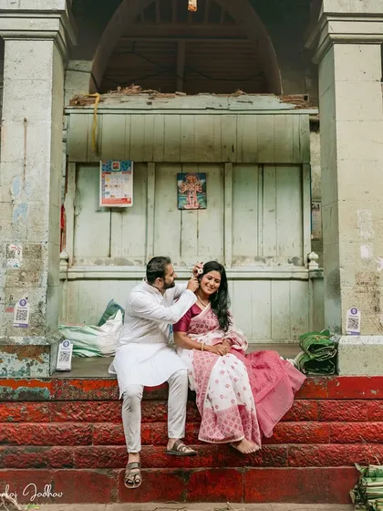 A sweet, playful moment on the steps of an old building in Pune. Parth gently places a flower in Chaitrali's hair, a simple gesture full of love.