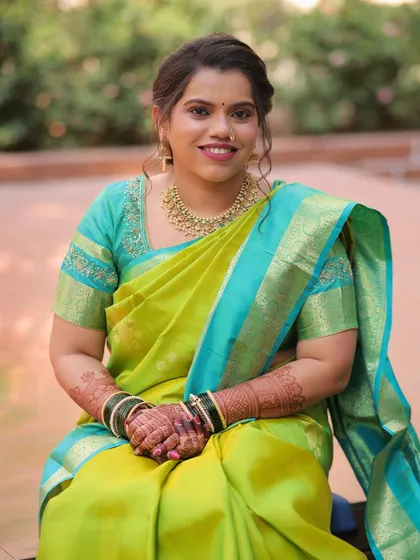 This seated portrait showcases the beautiful drape of her saree and the intricate details of her henna, all complemented by a fresh and glowing makeup look.