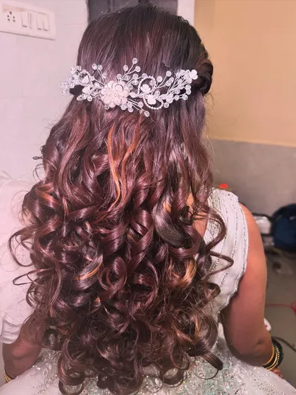 A beautiful hairstyle with soft curls and a sparkling hair accessory. This is a perfect choice for a reception or engagement look.