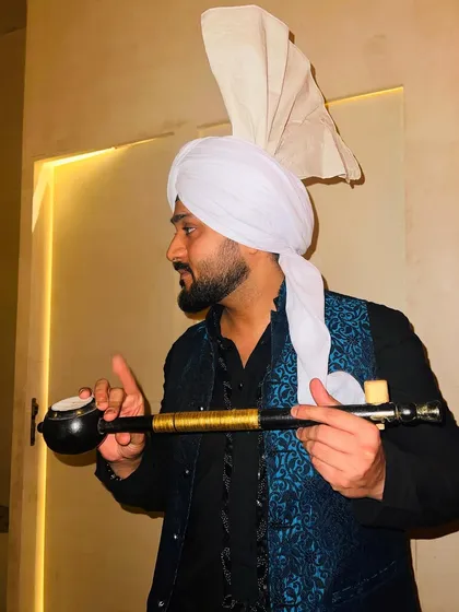 Holding a 'Tumbi', a classic Punjabi folk instrument, while sporting the turban look.