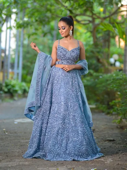 A stunning dusty blue lehenga, fully adorned with intricate sequin work in a swirling rose pattern. This modern outfit is a fantastic choice for a sangeet night or a glamorous reception party.