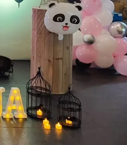 A panda foil balloon and other small props like birdcages add detail to the party setup.