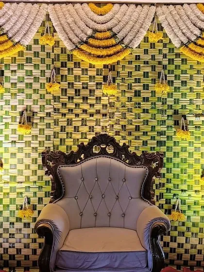 This is a classic South Indian seemantha setup featuring a backdrop of intricately woven coconut leaves. We pair it with an ornate chair to make the mom-to-be feel like a queen on her special day.