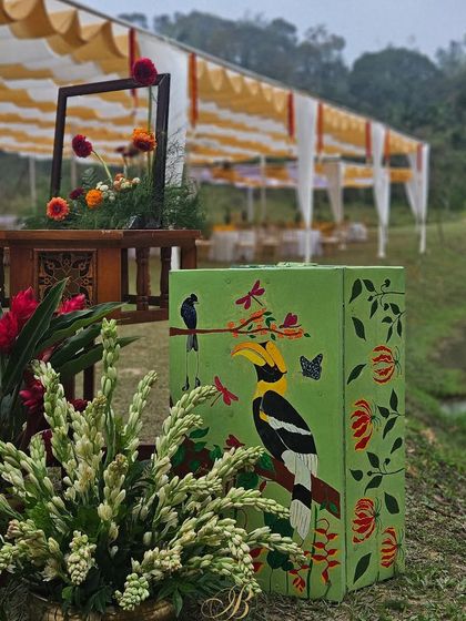 A closer view of the hand-painted trunk featuring the Malabar Hornbill, surrounded by locally sourced flowers and foliage.