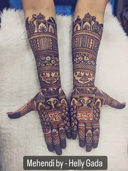 When every inch of your hand tells a story. This is a classic full-hand bridal design with matching arms, featuring peacocks and architectural domes for a regal feel.