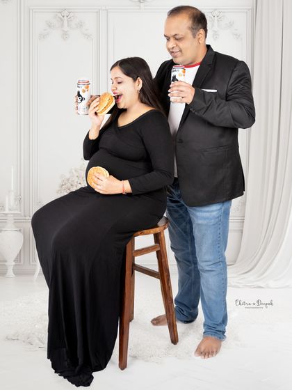 Cheers to cravings! This fun shot captures the reality of pregnancy cravings with a humorous twist, as dad cheers on mom and her burgers.