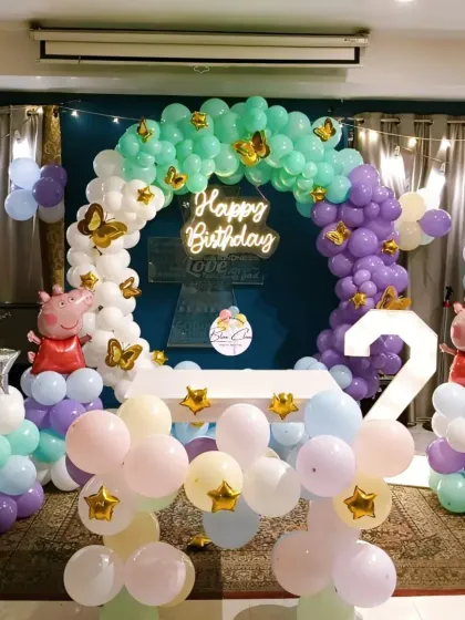 A lovely Peppa Pig and butterfly themed second birthday, featuring a pastel balloon arch and neon sign.