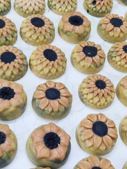 A collection of sunflower-shaped Ubtan cold process soaps.
