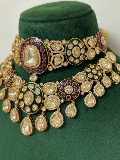 This two-piece necklace set features unique geometric and circular patterns with Meenakari work. It's a bold rental choice for a modern bride.