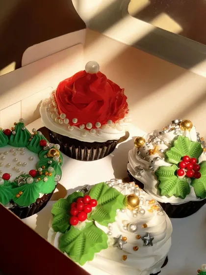 A close-up look at the details on my Christmas cupcakes. I use tiny pearls, stars, and hand-piped holly leaves to make each one a tiny piece of edible art.