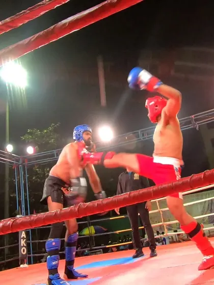 A high kick narrowly misses, demonstrating the speed and reflexes required in K1 kickboxing.