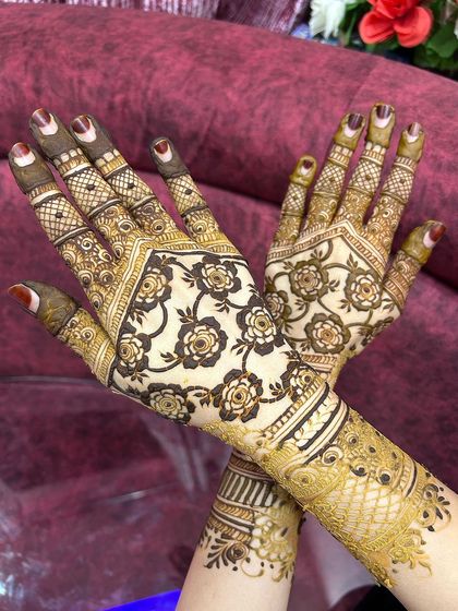 A crossed-hands pose showing the beautiful symmetry of the floral design on the back of the hands.