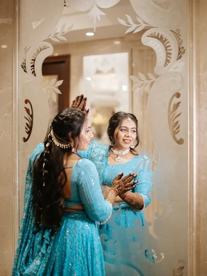 A moment of reflection. The bride's soft makeup and beautiful braided hairstyle are seen in this artistic mirror shot.