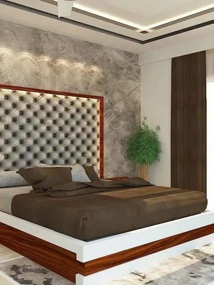 This design focuses on classic luxury. The oversized, button-tufted leatherette headboard creates a grand focal point, while the concrete-textured wall adds a modern contrast.