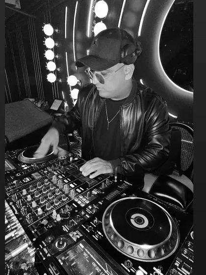 A black and white shot of me focused on the mix during a reception party. It captures the concentration it takes to seamlessly blend tracks and read the energy of the dance floor.