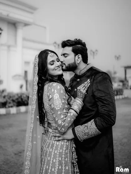 A sweet and romantic black and white shot of the groom kissing his bride's cheek. This timeless image beautifully captures the affection and joy of their engagement day.