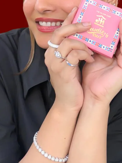 Your favorite piece is just a DM away. A happy client holding our signature pink box, showcasing her beautiful rings and bracelet.