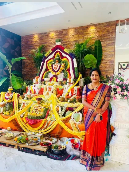 Our happy client Meena celebrating a festival at home, draped in a beautiful red Kanchipuram silk saree.