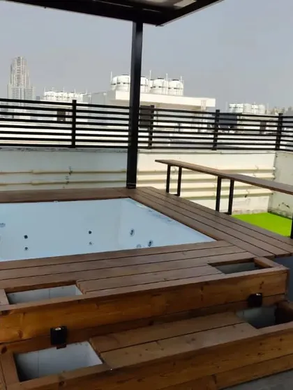 The jacuzzi deck includes built-in steps and planters, making it a fully integrated and functional feature of the terrace.