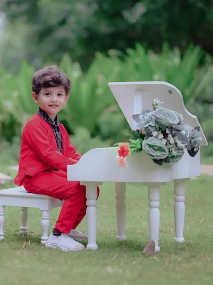 Looking sharp in his red suit, this young man is ready for his piano recital. Themed shoots like this are a fun way to let kids play and be themselves, which always results in the best photos.