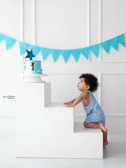 Reaching for the prize! A cute action shot of the birthday boy climbing towards his cake on our versatile white steps prop.