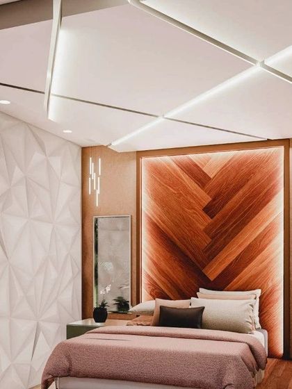 This angle highlights the geometric false ceiling with strip lighting and the 3D panel accent wall, which add depth and modernity to the bedroom.