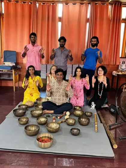 The same group of graduates, making a gesture of mindfulness and connection after their training.