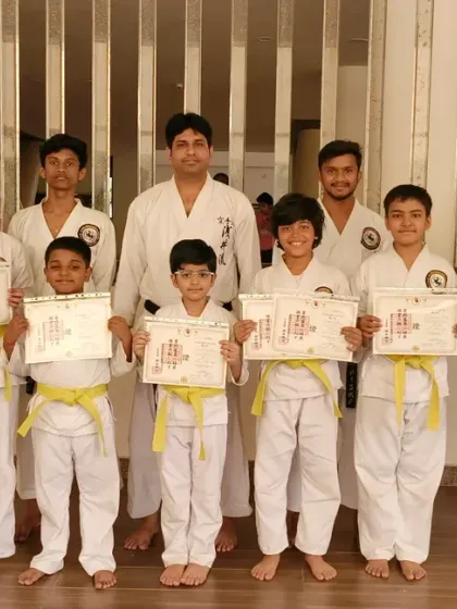 A proud group of new yellow belts from our Virar branch, holding their certificates of achievement.