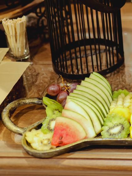 A close-up of the artfully arranged fruit platter, showing sliced apples, kiwi, watermelon, and oranges. The meticulous presentation demonstrates my attention to detail.