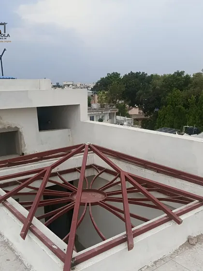 The framework for a pyramid-shaped skylight under construction on a rooftop. This design will create a striking architectural feature, channeling light down into the center of the building.
