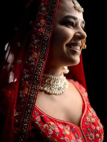 A close-up of the bride's radiant smile. This shot perfectly captures her happiness and the beautiful details of her makeup and jewelry.