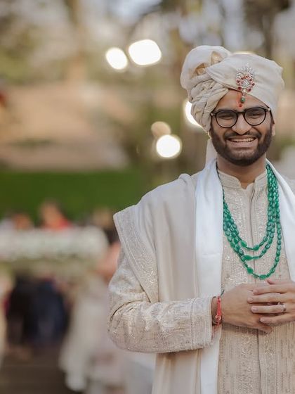 The groom's happy and expectant smile as he waits for his bride.