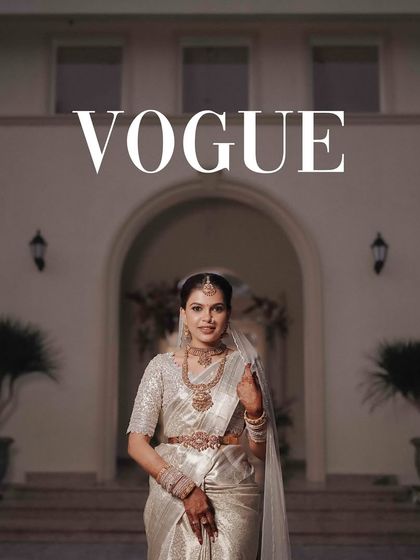 A "Vogue" inspired shot of the bride in a magnificent silver saree, standing before a grand villa.