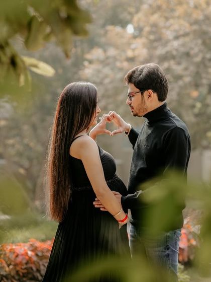 A creative shot through the leaves, creating a natural frame around the couple as they share an intimate moment. This technique adds a sense of privacy and romance.