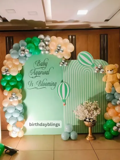 A "Baby is Blooming" baby shower with a hot air balloon theme. The mint green and peach color palette is soft and welcoming.