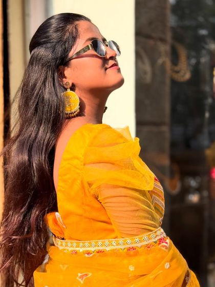 Strike a pose in this vibrant yellow lehenga, perfect for a fun-filled Haldi ceremony. The puff sleeves add a trendy touch to the traditional outfit.