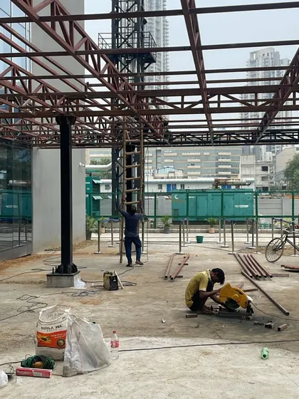 On-site at Heritage Xperiential School, workers assemble the metal truss for the entrance. This phase is critical, as the raw materials and structural connections begin to reveal the tangible form of our design intent.