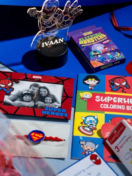 A closer look at the personalized items in our Superhero hamper, including a custom Iron Man LED lamp with the child's name, a Spiderman photo frame, and a Superman Rakhi.