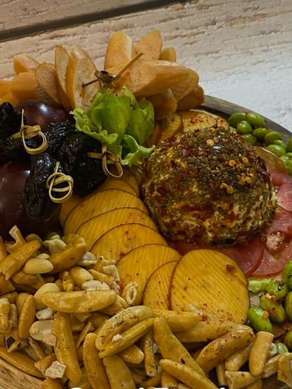 A savoury platter featuring a spiced cheese ball, assorted nuts, crackers, and dried fruits. A wonderful mix of sweet and savoury.