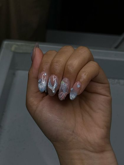 Glistening silver and white nails with delicate 3D chrome details, created by our students to start the week with some sparkle.