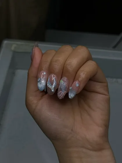 Glistening silver and white nails with delicate 3D chrome details, created by our students to start the week with some sparkle.