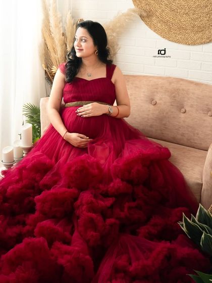 A moment of quiet reflection for the mom-to-be. Seated in a stunning red ruffled gown, this portrait captures the peaceful side of waiting for your baby.